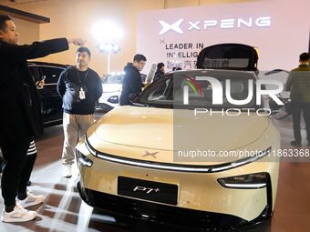 People view cars at the 16th Shandong International Auto Show in Qingdao, China, on December 13, 2024. (