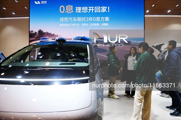 People view cars at the 16th Shandong International Auto Show in Qingdao, China, on December 13, 2024. 