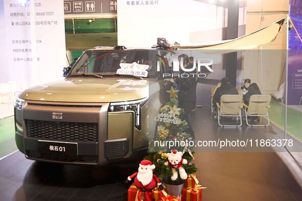 People view cars at the 16th Shandong International Auto Show in Qingdao, China, on December 13, 2024. 