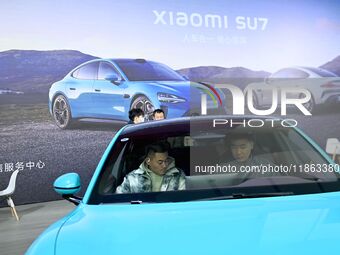 People view cars at the 16th Shandong International Auto Show in Qingdao, China, on December 13, 2024. (