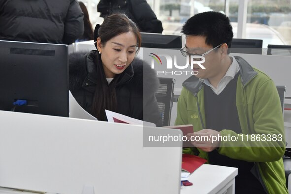 A staff member guides residents to register real estate at the Yongnian District Government Affairs Service center in Handan, China, on Dece...