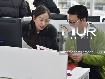 A staff member guides residents to register real estate at the Yongnian District Government Affairs Service center in Handan, China, on Dece...