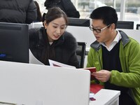 A staff member guides residents to register real estate at the Yongnian District Government Affairs Service center in Handan, China, on Dece...