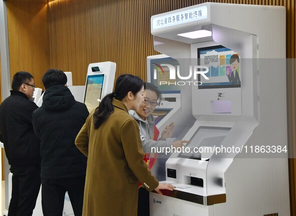 A staff member instructs residents to handle business using smart terminals of government affairs services at the Yongnian District governme...