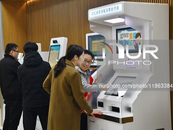 A staff member instructs residents to handle business using smart terminals of government affairs services at the Yongnian District governme...