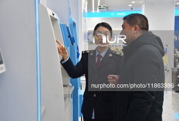 Tax officers guide residents to handle tax-related business at the tax service hall of Yongnian District Government Affairs Service Center i...