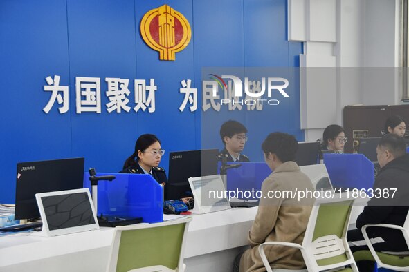 Tax officers handle business for taxpayers at the tax service hall of Yongnian District Government Affairs Service Center in Handan, North C...