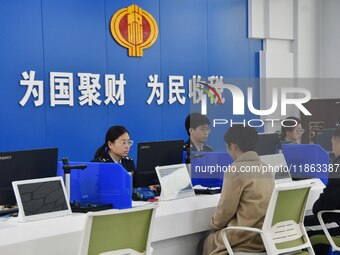 Tax officers handle business for taxpayers at the tax service hall of Yongnian District Government Affairs Service Center in Handan, North C...