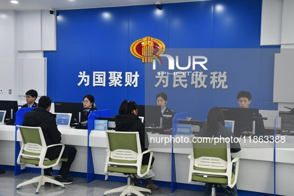 Tax officers handle business for taxpayers at the tax service hall of Yongnian District Government Affairs Service Center in Handan, North C...