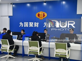 Tax officers handle business for taxpayers at the tax service hall of Yongnian District Government Affairs Service Center in Handan, North C...