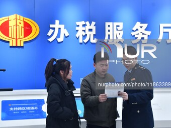 Tax officials explain tax reduction and fee reduction policies to taxpayers at the tax service hall of Yongnian District Government Affairs...