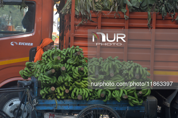 Indian workers unload bananas from a vehicle at a regulated market in Siliguri, India, on December 13, 2024. 