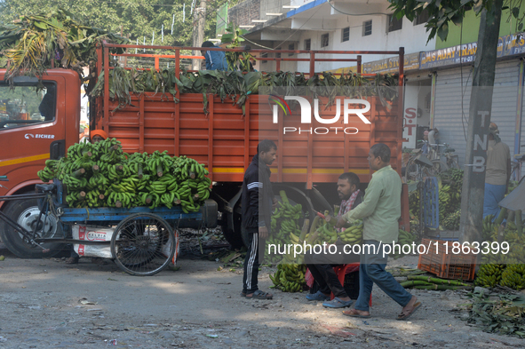 Indian workers unload bananas from a vehicle at a regulated market in Siliguri, India, on December 13, 2024. 