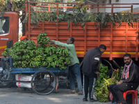 Indian workers unload bananas from a vehicle at a regulated market in Siliguri, India, on December 13, 2024. (