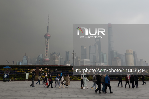 Chinese and foreign tourists view the Lujiazui high-rise buildings across the Huangpu River near the Bund landscape platform in Shanghai, Ch...