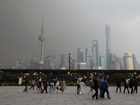 Chinese and foreign tourists view the Lujiazui high-rise buildings across the Huangpu River near the Bund landscape platform in Shanghai, Ch...