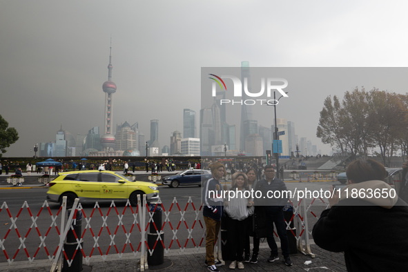 Chinese and foreign tourists view the Lujiazui high-rise buildings across the Huangpu River near the Bund landscape platform in Shanghai, Ch...