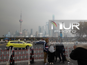 Chinese and foreign tourists view the Lujiazui high-rise buildings across the Huangpu River near the Bund landscape platform in Shanghai, Ch...