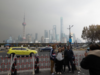 Chinese and foreign tourists view the Lujiazui high-rise buildings across the Huangpu River near the Bund landscape platform in Shanghai, Ch...