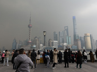 Chinese and foreign tourists view the Lujiazui high-rise buildings across the Huangpu River near the Bund landscape platform in Shanghai, Ch...