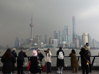 Chinese and foreign tourists view the Lujiazui high-rise buildings across the Huangpu River near the Bund landscape platform in Shanghai, Ch...