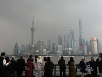 Chinese and foreign tourists view the Lujiazui high-rise buildings across the Huangpu River near the Bund landscape platform in Shanghai, Ch...