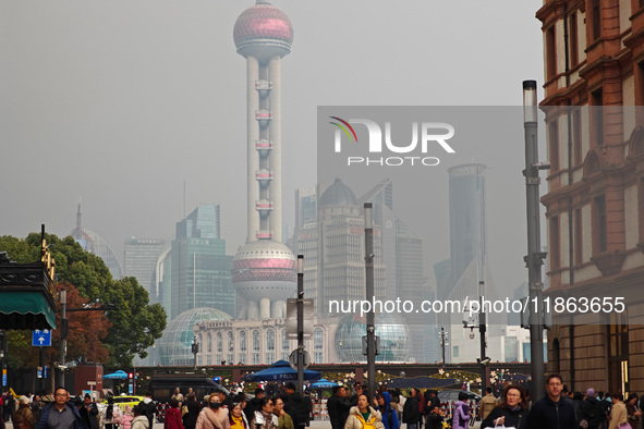 Chinese and foreign tourists view the Lujiazui high-rise buildings across the Huangpu River near the Bund landscape platform in Shanghai, Ch...