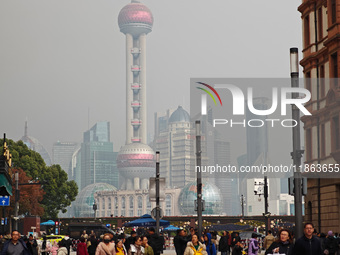 Chinese and foreign tourists view the Lujiazui high-rise buildings across the Huangpu River near the Bund landscape platform in Shanghai, Ch...