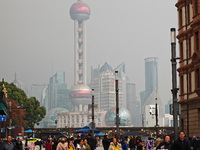 Chinese and foreign tourists view the Lujiazui high-rise buildings across the Huangpu River near the Bund landscape platform in Shanghai, Ch...