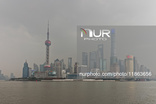 Chinese and foreign tourists view the Lujiazui high-rise buildings across the Huangpu River near the Bund landscape platform in Shanghai, Ch...