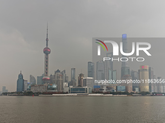 Chinese and foreign tourists view the Lujiazui high-rise buildings across the Huangpu River near the Bund landscape platform in Shanghai, Ch...