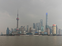 Chinese and foreign tourists view the Lujiazui high-rise buildings across the Huangpu River near the Bund landscape platform in Shanghai, Ch...