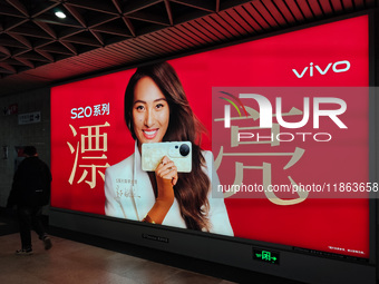 An LED screen displays tennis star Zheng Qinwen's vivo mobile phone advertisement in a subway transfer channel in Shanghai, China, on Decemb...