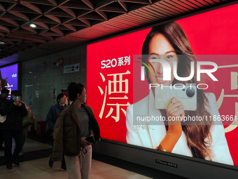 An LED screen displays tennis star Zheng Qinwen's vivo mobile phone advertisement in a subway transfer channel in Shanghai, China, on Decemb...