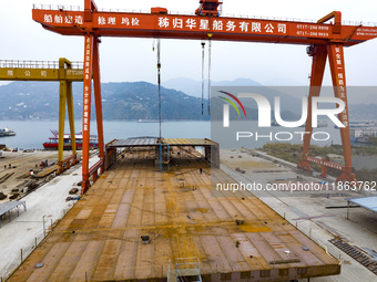 Workers build a new energy vehicle ro-ro ship at the Huaxing Ship Construction base in Zigui County, Yichang City, Hubei province, China, on...