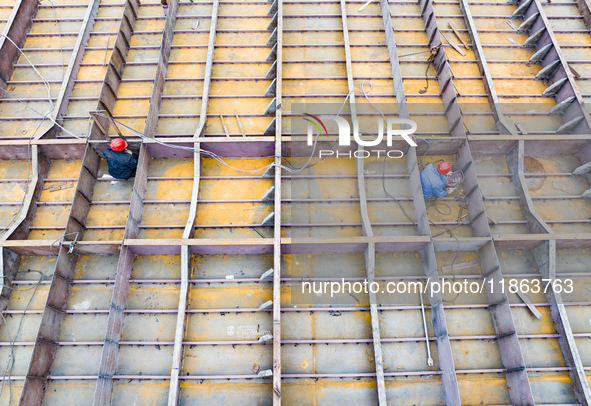 Workers build a new energy vehicle ro-ro ship at the Huaxing Ship Construction base in Zigui County, Yichang City, Hubei province, China, on...