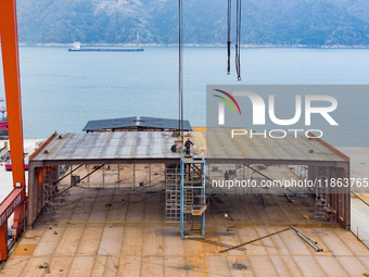 Workers build a new energy vehicle ro-ro ship at the Huaxing Ship Construction base in Zigui County, Yichang City, Hubei province, China, on...