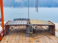 Workers build a new energy vehicle ro-ro ship at the Huaxing Ship Construction base in Zigui County, Yichang City, Hubei province, China, on...