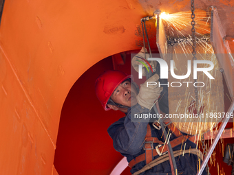 Workers build a new energy vehicle ro-ro ship at the Huaxing Ship Construction base in Zigui County, Yichang City, Hubei province, China, on...