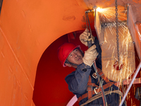 Workers build a new energy vehicle ro-ro ship at the Huaxing Ship Construction base in Zigui County, Yichang City, Hubei province, China, on...