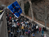 Private sector workers, students, and protesters take to the streets for a demonstration against the Georgian government's postponement of E...