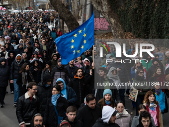 Private sector workers, students, and protesters take to the streets for a demonstration against the Georgian government's postponement of E...