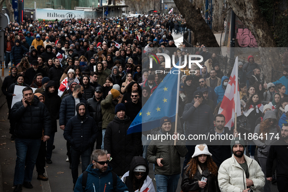 Private sector workers, students, and protesters take to the streets for a demonstration against the Georgian government's postponement of E...