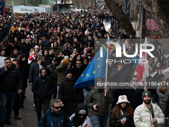 Private sector workers, students, and protesters take to the streets for a demonstration against the Georgian government's postponement of E...