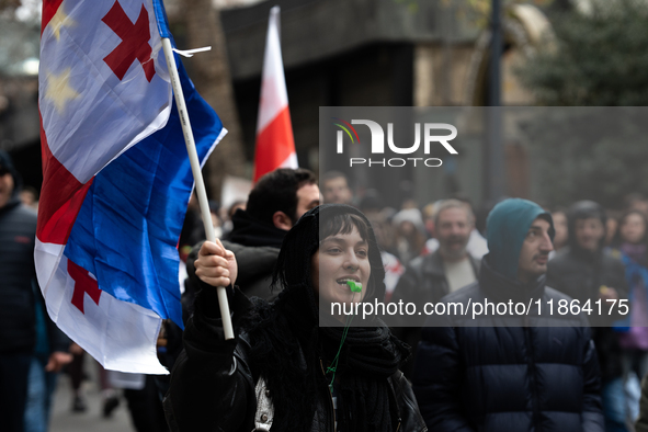 Private sector workers, students, and protesters take to the streets for a demonstration against the Georgian government's postponement of E...