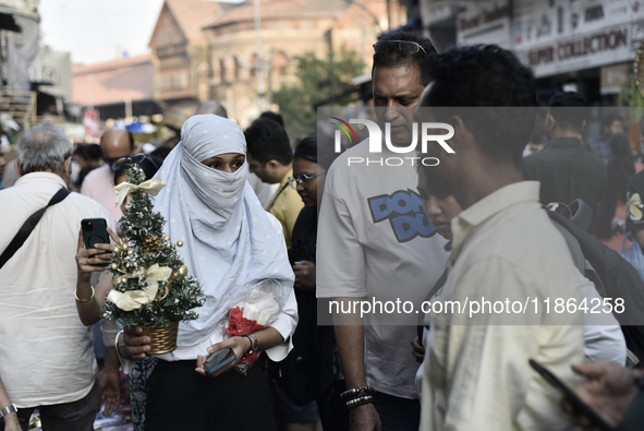 Shoppers look at decorative items displayed at a market ahead of the Christmas celebrations in Mumbai, India, on December 13, 2024. 