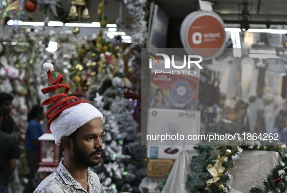 A man wears a Santa Claus cap at a market ahead of the Christmas celebrations in Mumbai, India, on December 13, 2024. 