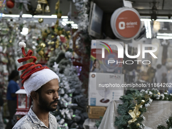 A man wears a Santa Claus cap at a market ahead of the Christmas celebrations in Mumbai, India, on December 13, 2024. (