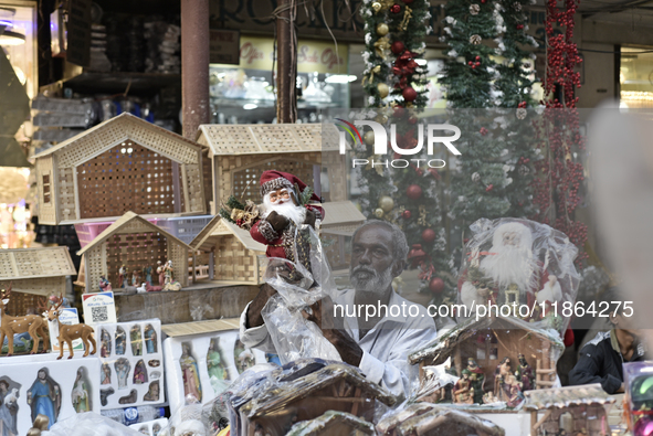 A shopkeeper sells Santa Claus at a market ahead of the Christmas celebrations in Mumbai, India, on December 13, 2024. 