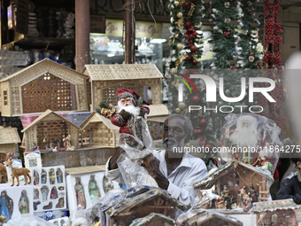 A shopkeeper sells Santa Claus at a market ahead of the Christmas celebrations in Mumbai, India, on December 13, 2024. (